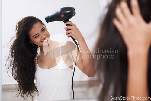 Image of Blow dry, home and woman with hair care, happy and mirror with treatment, grooming and routine. Person, smile and girl with salon equipment, texture and volume with shine, glowing and wellness