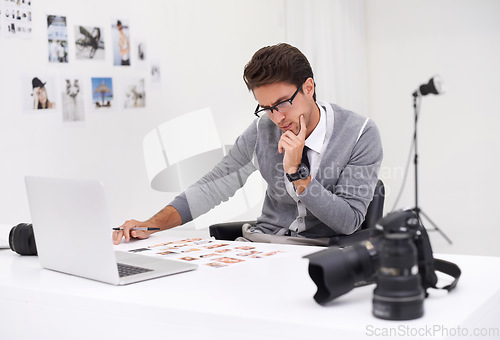 Image of Photographer, editing and thinking with computer in office with media, process and production. Professional, editor and creative person with choice on laptop with photoshoot results or cinematography