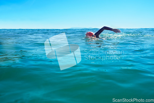 Image of Swimming, stroke and person in ocean water in summer for exercise, training or workout on mockup space. Sea, sport and a young athlete outdoor for fitness, health and triathlon competition in nature