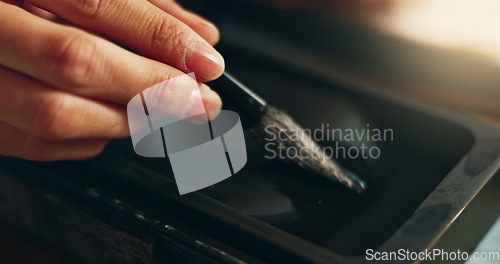 Image of Hand, closeup of brush in ink for writing and calligraphy or ancient stationery for art and inkstone. Japanese creativity, black paint with paintbrush and person stroke with traditional vintage tools