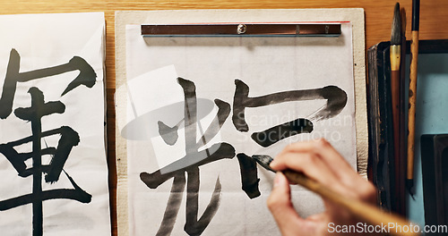 Image of Man, calligraphy or hands of a Japanese artist in studio for art and script, letter with closeup for alphabet. Start, top or male person with tools, paintbrush and focus with traditional stationery