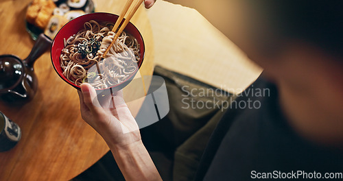 Image of Closeup of bowl of noodles, hands and person is eating food, nutrition and sushi with chopsticks in Japan. Hungry for Japanese cuisine, soup and Asian culture, traditional meal for lunch or dinner