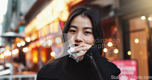 Image of Travel, eating and Asian woman with onigiri in the city on exploring vacation, adventure or holiday.Portrait, food and young female person enjoying a Japanese snack or meal in town on weekend trip.