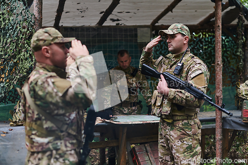 Image of A dedicated soldier salutes his elite unit, showcasing camaraderie and readiness for the most perilous military operations