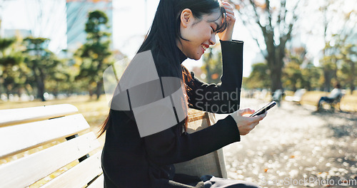 Image of Japanese woman, bench and smartphone in park with relax, happiness and social media in sunshine in city. Female person, sitting and wellness with cellphone in town, streaming and digital technology