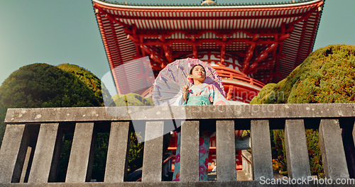 Image of Japanese woman, umbrella and shinto temple with traditional clothes, culture and religion in sunshine. Person, girl and parasol for walk with faith, mindfulness and thinking with low angle in Kyoto