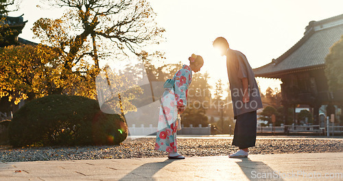Image of Japanese people at temple, bow and traditional clothes with hello, nature and sunshine with respect and culture. Couple outdoor, greeting with modesty and tradition, polite and kind for religion