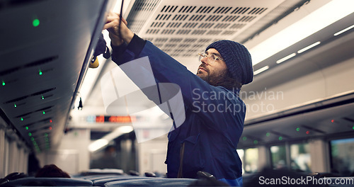 Image of Man, train travel and overhead luggage compartment for storage, safety and property with thinking. Person, guy and baggage in container for commute with railway infrastructure on holiday in Tokyo