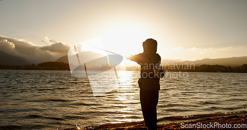 Image of Person, fishing and water in morning, sunrise and sport by ocean, lake and river with equipment in nature. Fisherman, line and catch fish for games, food and silhouette in sunshine, dawn and horizon