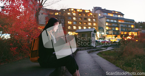 Image of Asian woman, phone and night at city for social media, communication or outdoor networking. Female person relax on mobile smartphone in the late evening for online chatting in urban town of Japan