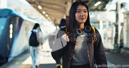 Image of Asian, woman at train station for travel, commute or holiday with smile on face and freedom outdoor. Railway, walking on platform and transportation, journey for adventure in China with happiness