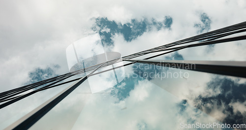 Image of Low angle, skyscraper building and clouds in city with reflection, nature and urban infrastructure. Architecture, cityscape and skyline and metro with landscape, glass and sky background in timelapse