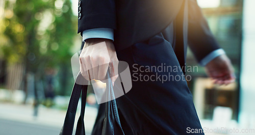 Image of Legs, walking and person with bag, travel in city street and carbon footprint with buildings and commuter moving. Eco friendly commute to work, hands with urban CBD and motion with sustainability