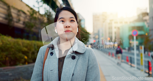 Image of Woman, Asian and walk on sidewalk, travel or commute to work with professional in city with earphones. Listening to music on journey, podcast and commuter on urban street in Tokyo with playlist