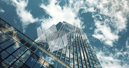 Image of Low angle, skyscraper building and clouds with reflection, nature or urban infrastructure in city. Architecture, cityscape and skyline and metro with landscape, glass and sky background in timelapse