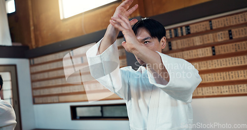 Image of Man, martial arts and training aikido in dojo or self defence wellness, practice or combat sports. Male person, gee uniform and hands or Japanese exercise for battle challenge, fitness or fight power
