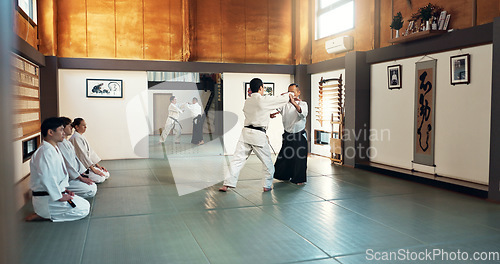 Image of Aikido, sensei and Japanese students with training, fitness and action in class for defence or technique. Martial arts, people or fighting with discipline, uniform or confidence for culture and skill