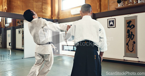 Image of Aikido, master and fight with a sensei in martial arts with student of self defence, discipline and training. Demonstration, class or Japanese man with black belt in fighting with education of skill