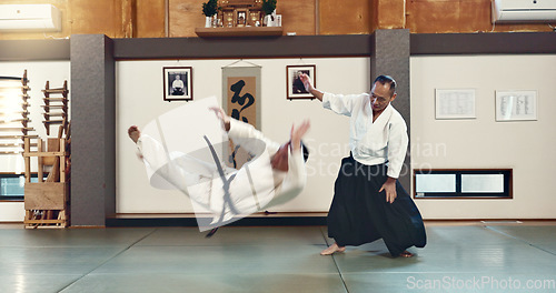 Image of Aikido, sensei and fight with a master in martial arts with student in self defence, discipline and training. Demonstration, class or Japanese man with black belt in fighting with education of skill