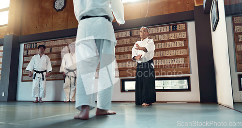 Image of Aikido, sensei and Japanese students with fitness, training and action in class for defence or technique. Martial arts, people or fighting with discipline, uniform or confidence for culture and skill