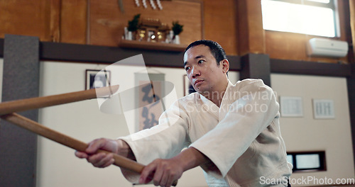 Image of Asian man, taekwondo and training with wooden sticks for martial arts, fighting or sparring partner in dojo. People in fight practice with dummy weapon to opponent in karate for self defense at gym