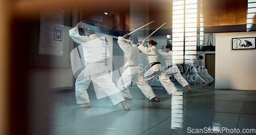 Image of Aikido, dojo class and people training for self defense, combat and Japanese group practice sword technique. Black belt students, transparent window and learning martial arts for safety protection