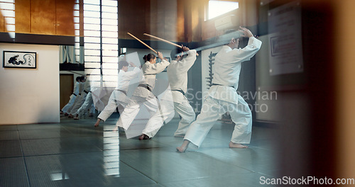 Image of Aikido, dojo class and people training for self defense, combat and Japanese group practice sword technique. Black belt students, transparent window and learning martial arts for safety protection