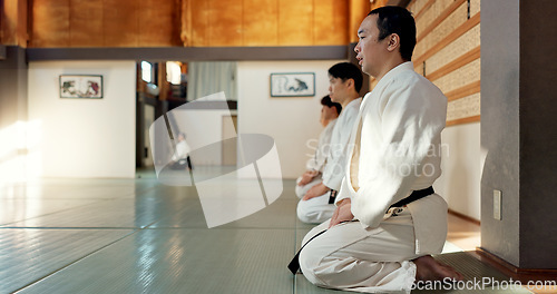 Image of Asian man, class and bow in dojo for respect, greeting or honor to master at indoor gym. Male person or group in karate bowing on floor for etiquette, attitude or commitment in martial arts together