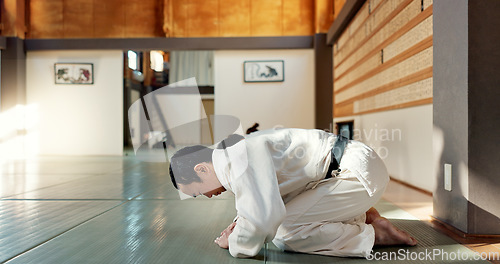 Image of Asian man, class and bow in dojo for respect, greeting or honor to master at indoor gym. Male person or group in karate bowing on floor for etiquette, attitude or commitment in martial arts together