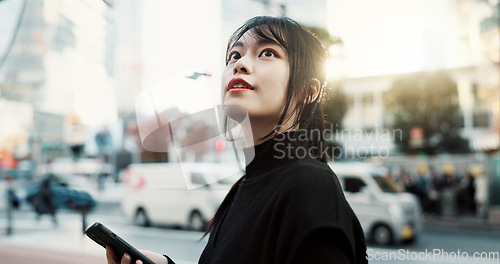 Image of Walking, phone and Japanese woman in the city for tourist sightseeing in the street on weekend trip. Adventure, travel and young female person commuting in road of urban town in Kyoto Japan.