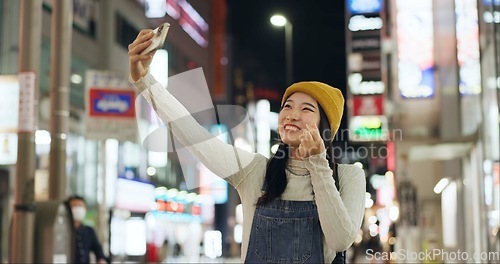 Image of Heart, hands and selfie by Japanese woman in a city for travel, adventure or journey outdoor. Love, emoji or happy lady influencer in Japan for content creation, blog or social media live streaming