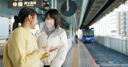 Image of Women, friends and train station or cellphone or Japanese, travel or social media. Female people, digital device and communication in Tokyo for public transport or vacation commute, urban or journey