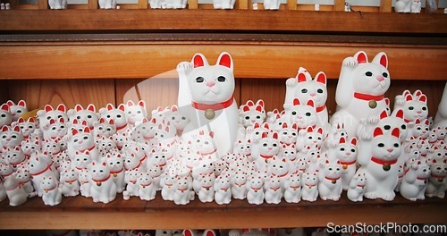 Image of Japanese, traditional and neko maneki or good luck cat in shop for fortune, culture or heritage. Sculpture figure, gotokuji statue and travel destination in Tokyo for local history, spiritual or gift