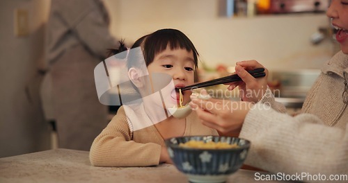 Image of Family, Japanese and woman feeding daughter in kitchen of home for growth, health or nutrition. Food, girl eating ramen noodles in apartment with mother and parent for diet or child development