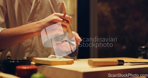 Image of Hands, food and chef cooking sushi in restaurant for traditional Japanese cuisine or dish closeup. Kitchen, table for seafood preparation and person working with gourmet meal recipe ingredients