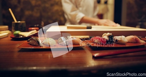 Image of Sushi, plate and serving with chef in restaurant for luxury cuisine or raw meal preparation closeup. Kitchen, food and presentation with person cooking local Japanese seafood for service in Tokyo