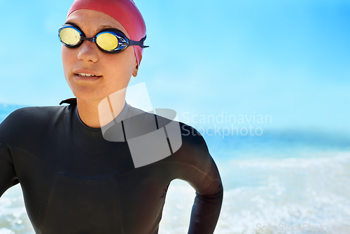 Image of Sports, goggles and woman swimming at the beach with blue sky for triathlon, race or competition training. Female Swimmer, athlete or person in ocean or sea for fitness workout or exercise for health