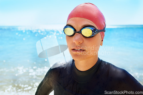 Image of Sports, goggles and woman swimming at the beach with blue sky for triathlon, race or competition training. Female Swimmer, athlete or person in ocean or sea for fitness workout or exercise for health