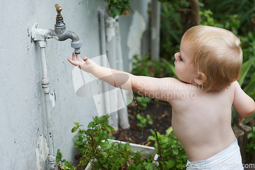 Image of Baby, playing with water and home in outdoor, development and growth for curiosity, backyard and diaper. Toddler, child and face in garden, alone and childhood memories for exploring with tap