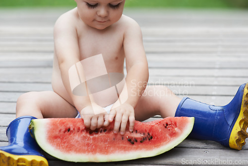 Image of Baby, playing with watermelon and outdoor, backyard and development with growth, curiosity and home. Toddler, child and infant in garden, alone and childhood for wellness, milestone and coordination