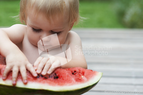 Image of Boy, playing with watermelon and fruit in backyard, outdoor and development with growth, fruit and home. Toddler, child and infant in garden, alone and childhood to eat, milestone or coordination