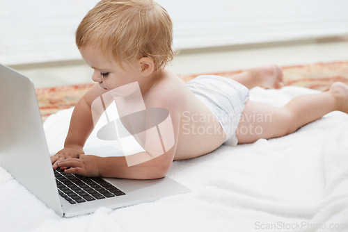 Image of Baby, playing and learning on laptop in home on bed with online games for education. Child, typing and relax with cartoon, movies or development of knowledge of technology with elearning for growth