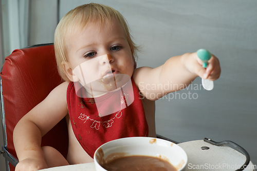 Image of Feeding chair, eating and baby with spoon in a house for food, nutrition and fun while playing. Food, messy eater and boy kid at home with meal for child development, diet or nutrition while learning