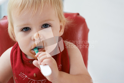 Image of Hungry, portrait and baby eating porridge for health, nutrition or child development at home. Food, cute and girl toddler or kid enjoying organic puree meal for lunch or dinner in high chair at house