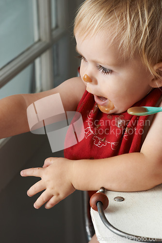 Image of Cute, feeding and baby eating porridge in high chair for nutrition, health and wellness at home. Sweet, playing and girl kid, infant or toddler enjoying puree food for child development at house.