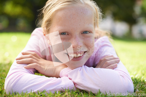 Image of Happy, portrait and girl child lying in grass for fun, play and adventure in nature. Face, smile and kid in garden with positive attitude, mindset and excited for exploring, learning or weekend break