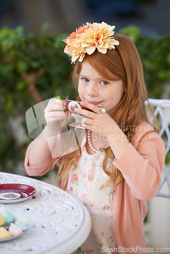 Image of Girl, child and portrait with tea in garden with party for birthday, celebration and playing outdoor in home. Person, kid and porcelain cup in backyard of house with dress up, happy and role play fun