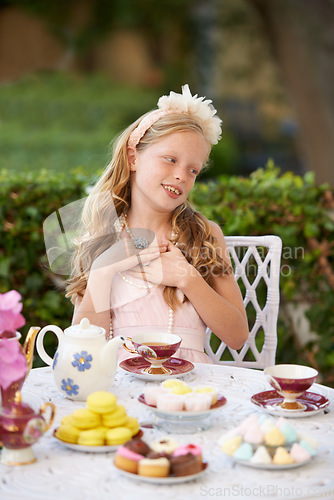 Image of Girl, child and happy at tea party in garden with face for birthday, celebration and playing outdoor in home. Person, kid and porcelain cups in backyard of house with dress up, beverage and role play