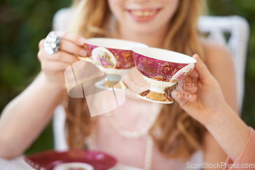 Image of Hands, tea cup and cheers, party and girl children playing with care, celebration and fun in backyard. Closeup of toast, beverage or drink with friends outdoor in garden for game or birthday