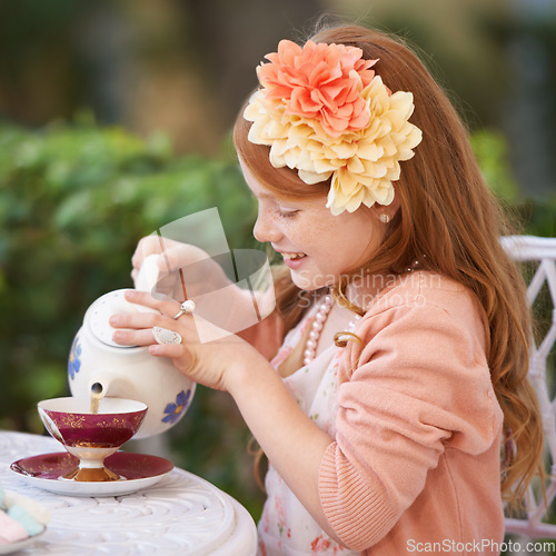 Image of Girl, child and tea party or outdoor play for fantasy fancy game for snack, birthday or beverage. Kid, youth and smile in backyard with cup for warm drink fr summer dress up, flowers or preschool